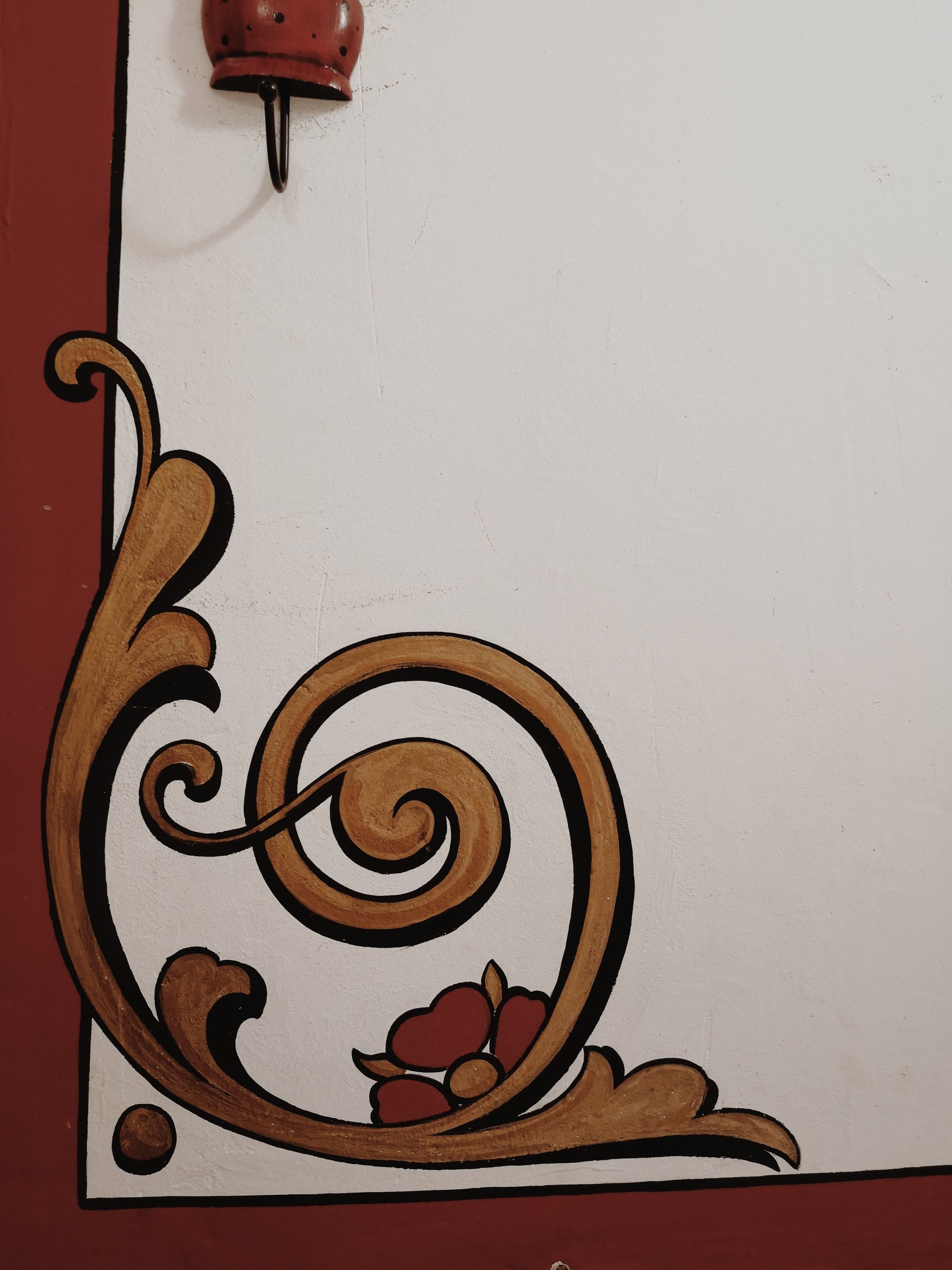 A decorative wall with a floral and scroll design.