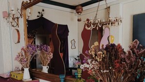 Una habitación con un espejo grande, un piano y muebles coloridos.