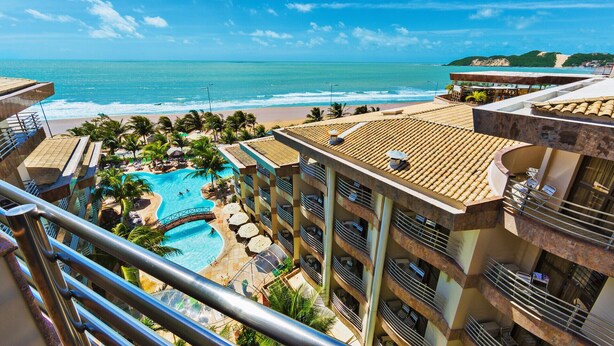 A hotel with a rooftop pool, balconies, and a view of the beach and ocean. - Esmeralda Praia Hotel (Natal)