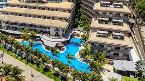 A hotel with multiple swimming pools, a central pool with a curved design, and surrounding palm trees. - Esmeralda Praia Hotel (Natal)