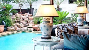 Una piscina al aire libre, sombrillas, sillones reclinables de piscina
