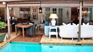 Una piscina al aire libre, sombrillas, sillones reclinables de piscina