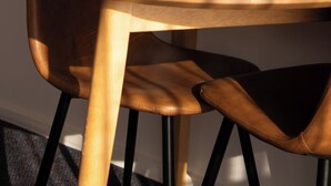 A round wooden table with a chair.