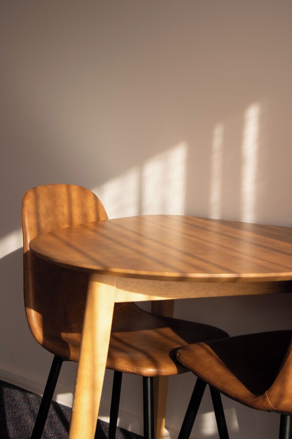 A round wooden table with a chair. - Harbour View Motel (Robe)