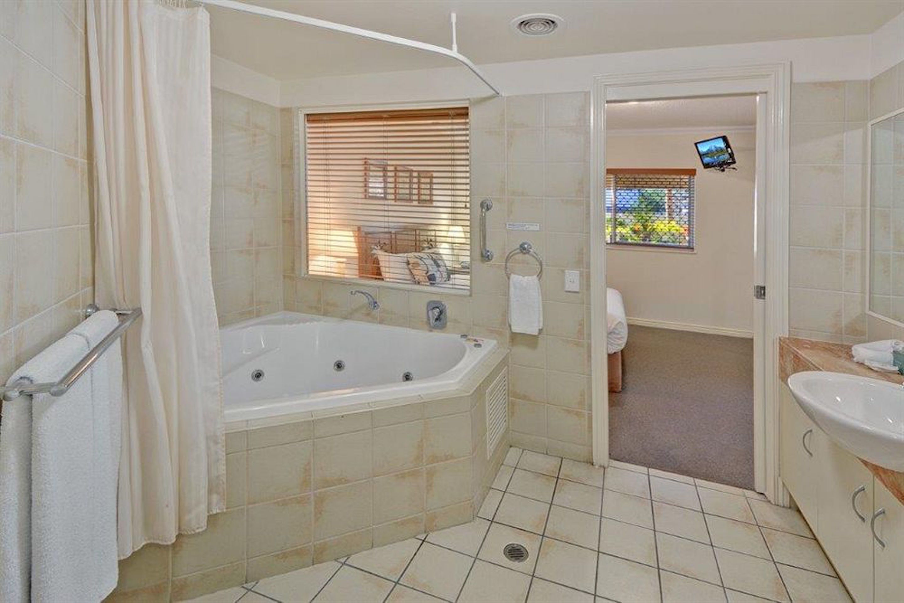 A bathroom with a bathtub, a shower area, and a sink.
