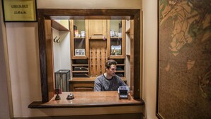 A reception desk with a 'CHECK OUT' sign, a wooden counter, and a map on the wall.