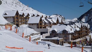 A ski resort with chalet-style buildings, ski lifts, and a snow-covered slope. - Résidence Tourmalet (Bagnères-de-Bigorre)