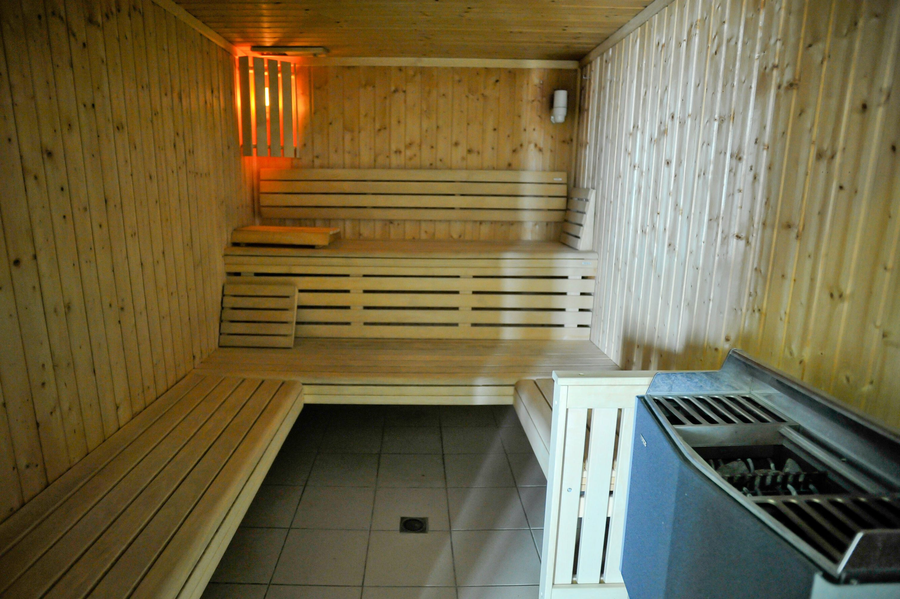 A sauna with wooden benches and a tiled floor.