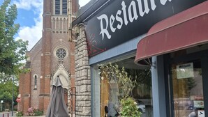 Un restaurante con un letrero que dice 'Restaurant' y un cartel que dice 'Paix Dieu' arriba.