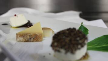 A dessert plate with various items including a piece of cheesecake, a scoop of ice cream, and a chocolate-covered treat.