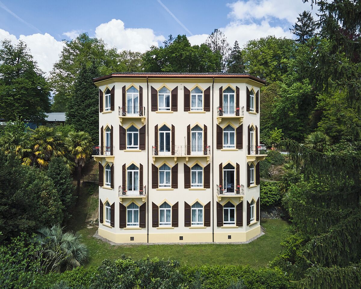 Un immeuble à étages doté d’une façade symétrique, de nombreux balcons et d’une pelouse bien entretenue.