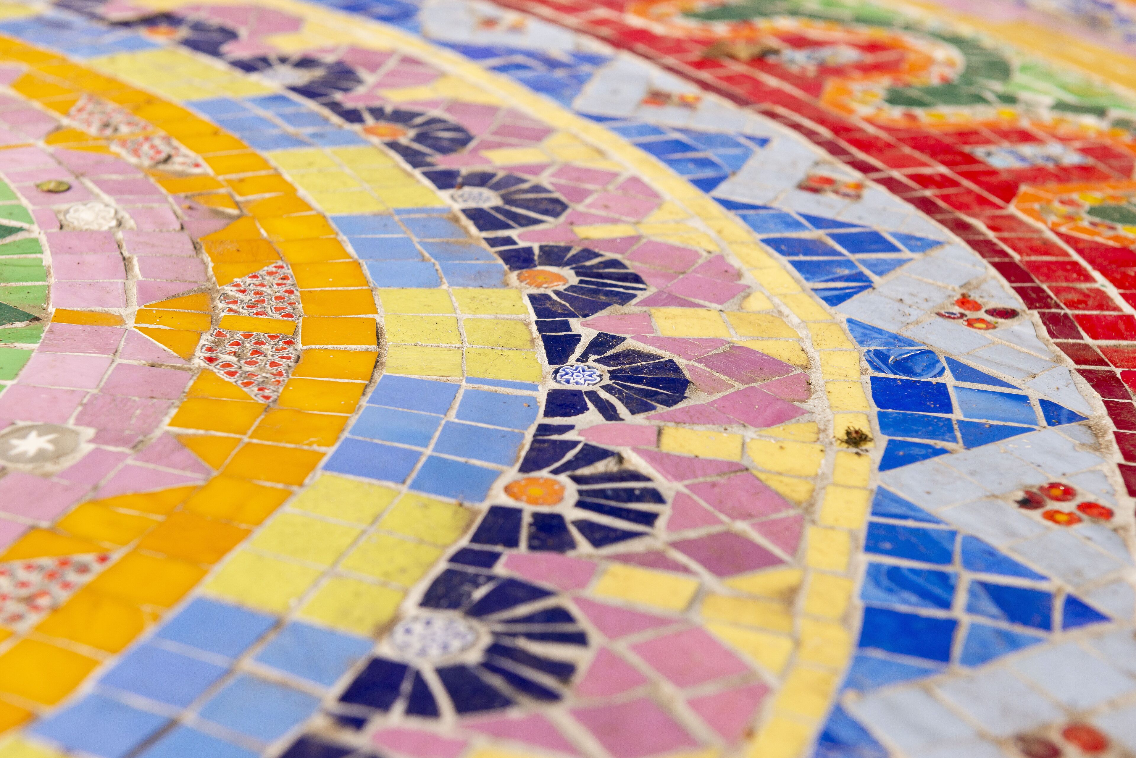 A close-up of a colorful mosaic floor with geometric patterns and floral designs.