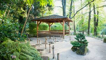 Escape to a serene garden oasis with a charming gazebo, surrounded by lush greenery and a variety of plants.