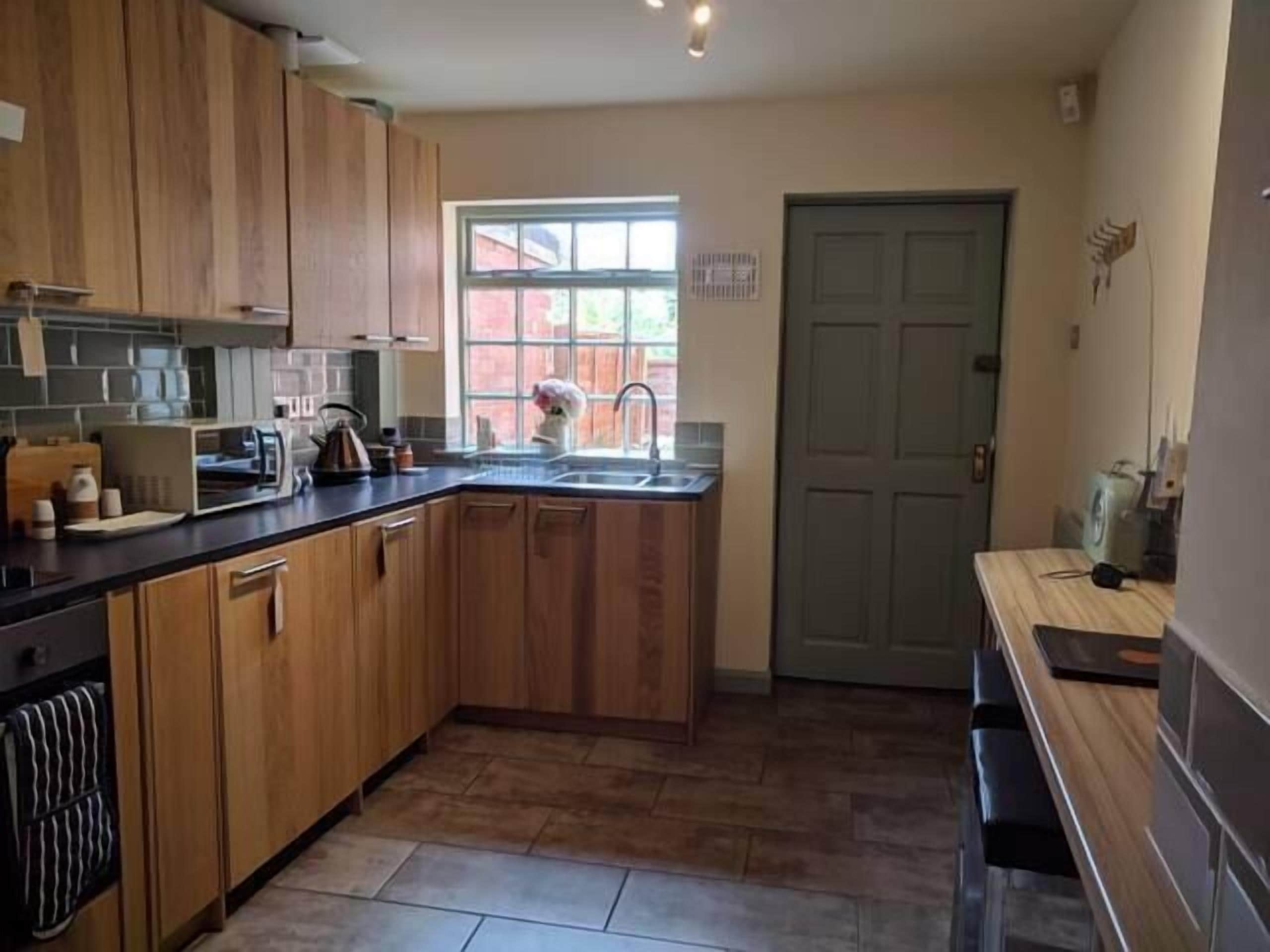 A kitchen with wooden cabinets, a sink, and a window.