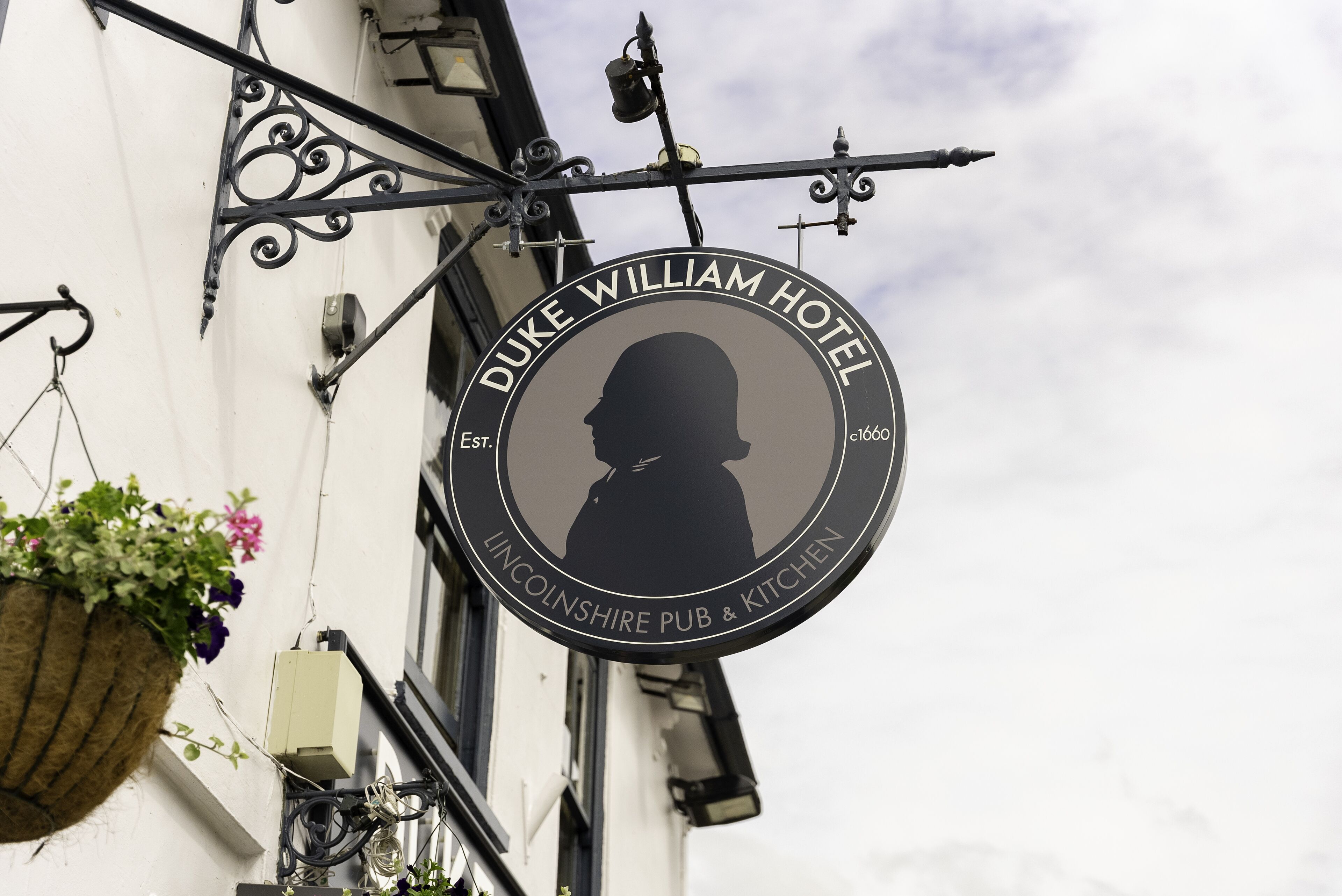 A circular sign with a silhouette of a man and the text "Duke William Hotel" and "Lincolnshire Pub & Kitchen".
