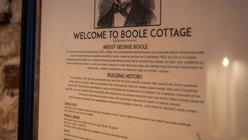 Letrero de bienvenida enmarcado para Boone Cottage, con detalles sobre su historia y servicios.