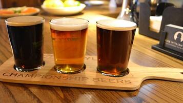 Tres vasos de cerveza sobre un posavasos de madera con el texto 'CHAMPIONSHIP BEERS'.