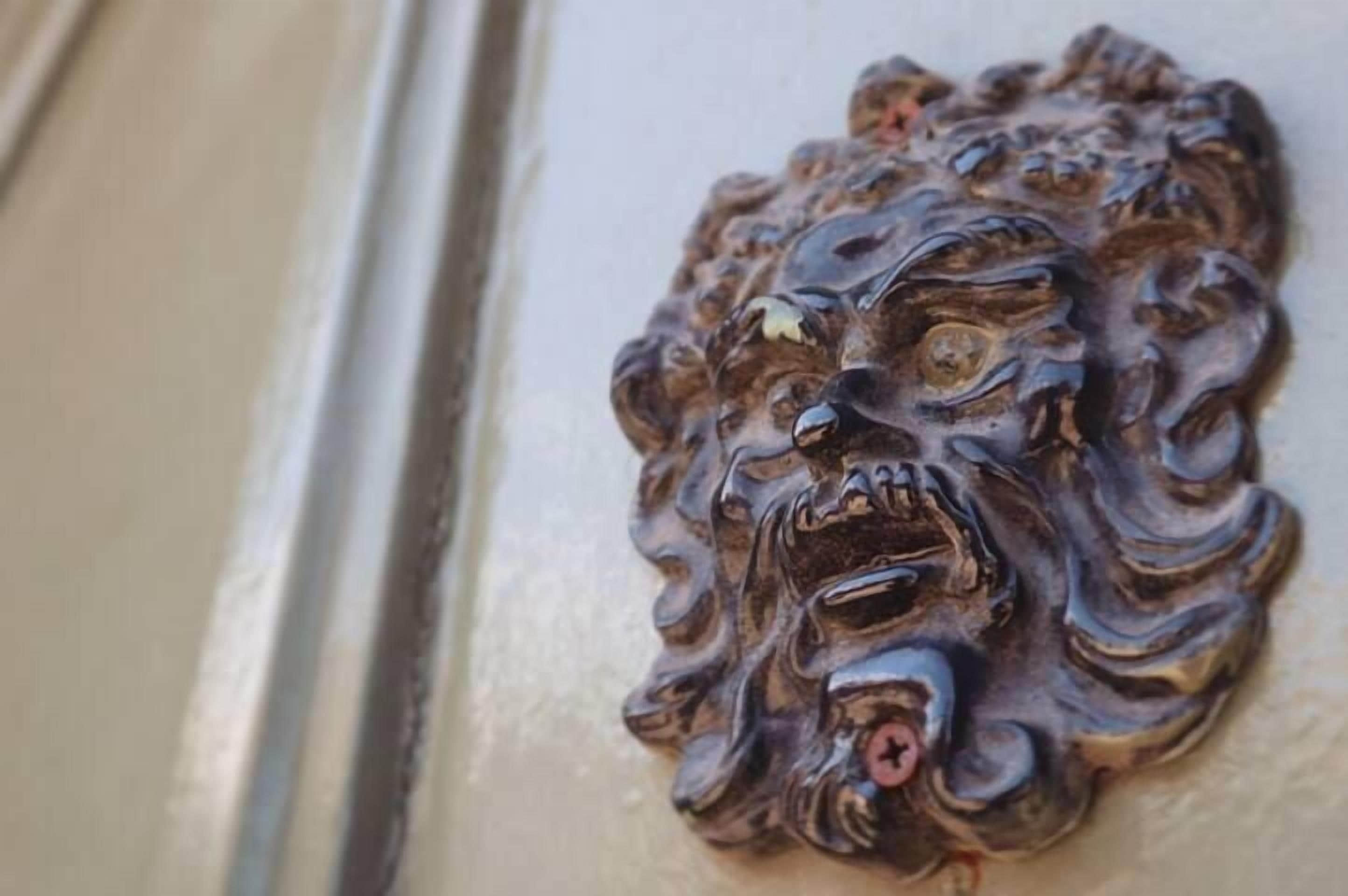 A decorative lion head emblem on a wall.