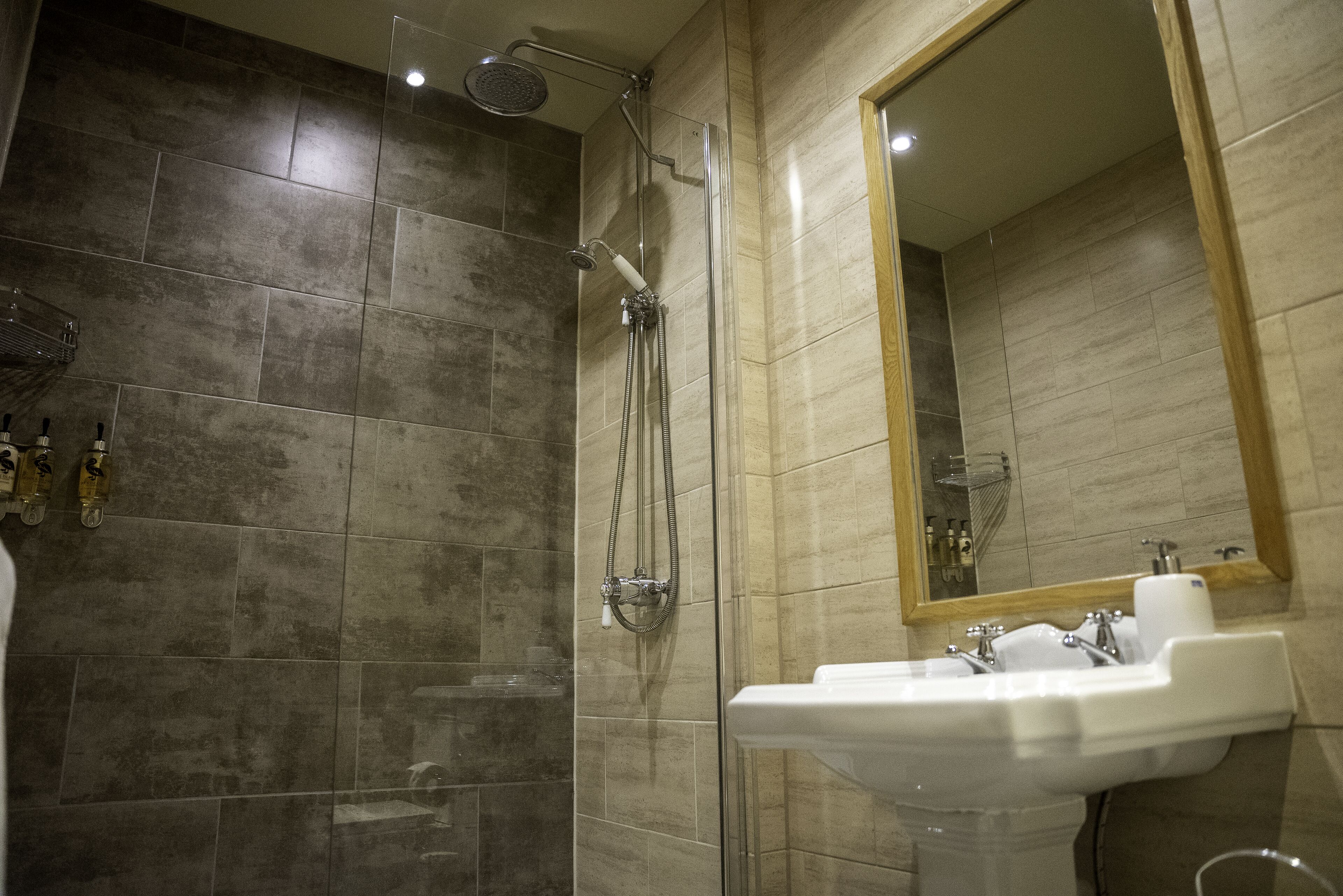 A modern bathroom with a shower, a sink, and a mirror.