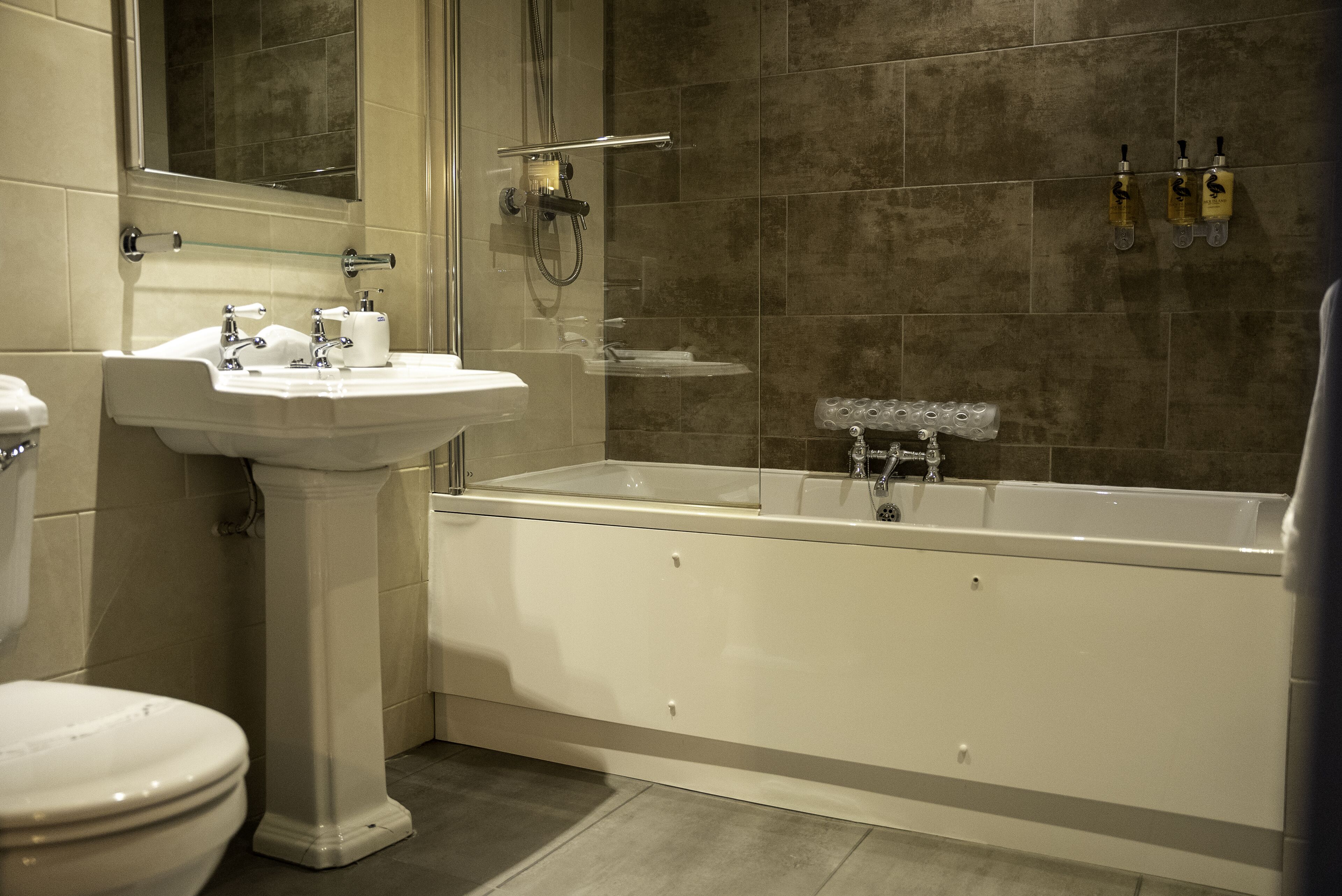 A bathroom with a pedestal sink, toilet, and a bathtub.