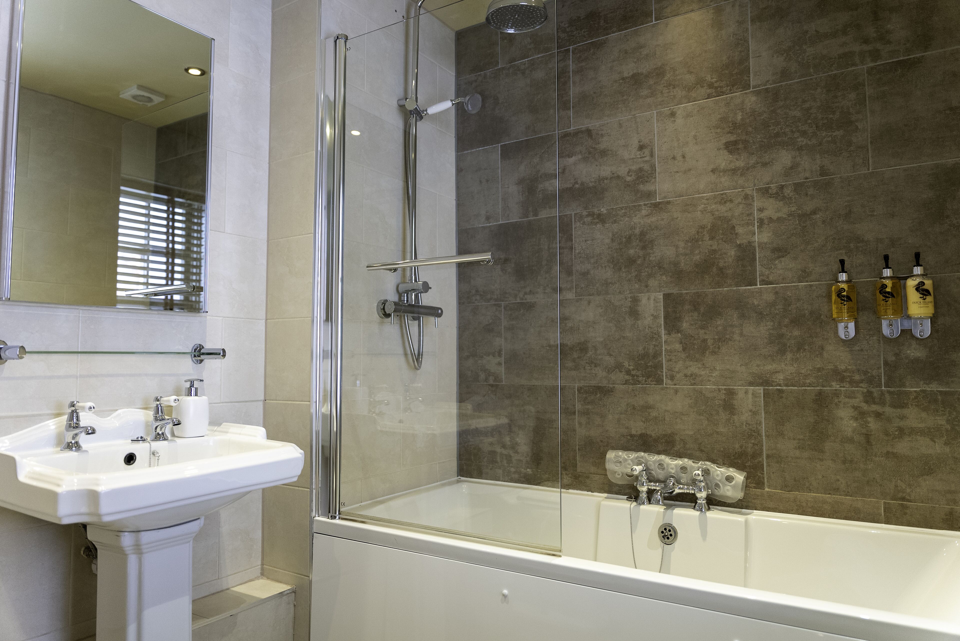 Un baño moderno con ducha de vidrio, lavamanos blanco y bañera.