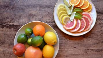 Two bowls of fruit on a wooden table.