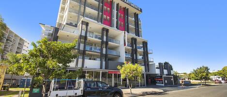 A multi-story building with balconies and a sign reading "The Chermside Apartments."