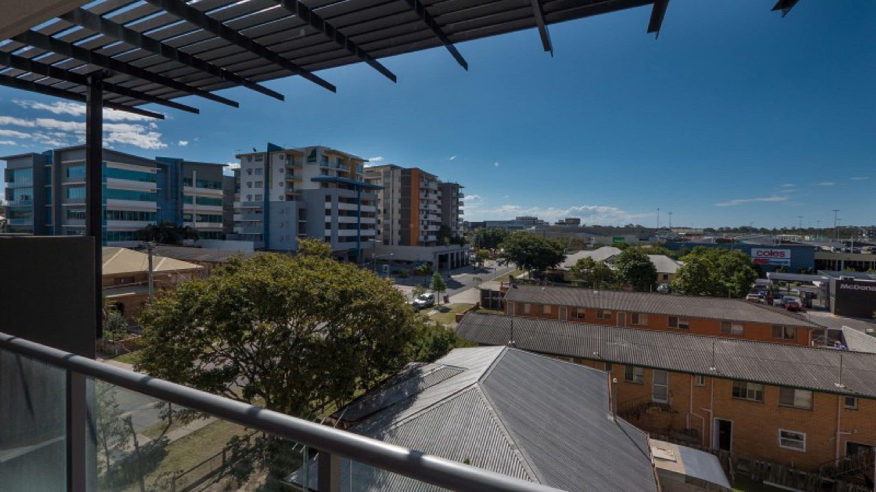 A residential area with modern apartment buildings, a McDonald's, and a Coles supermarket.
