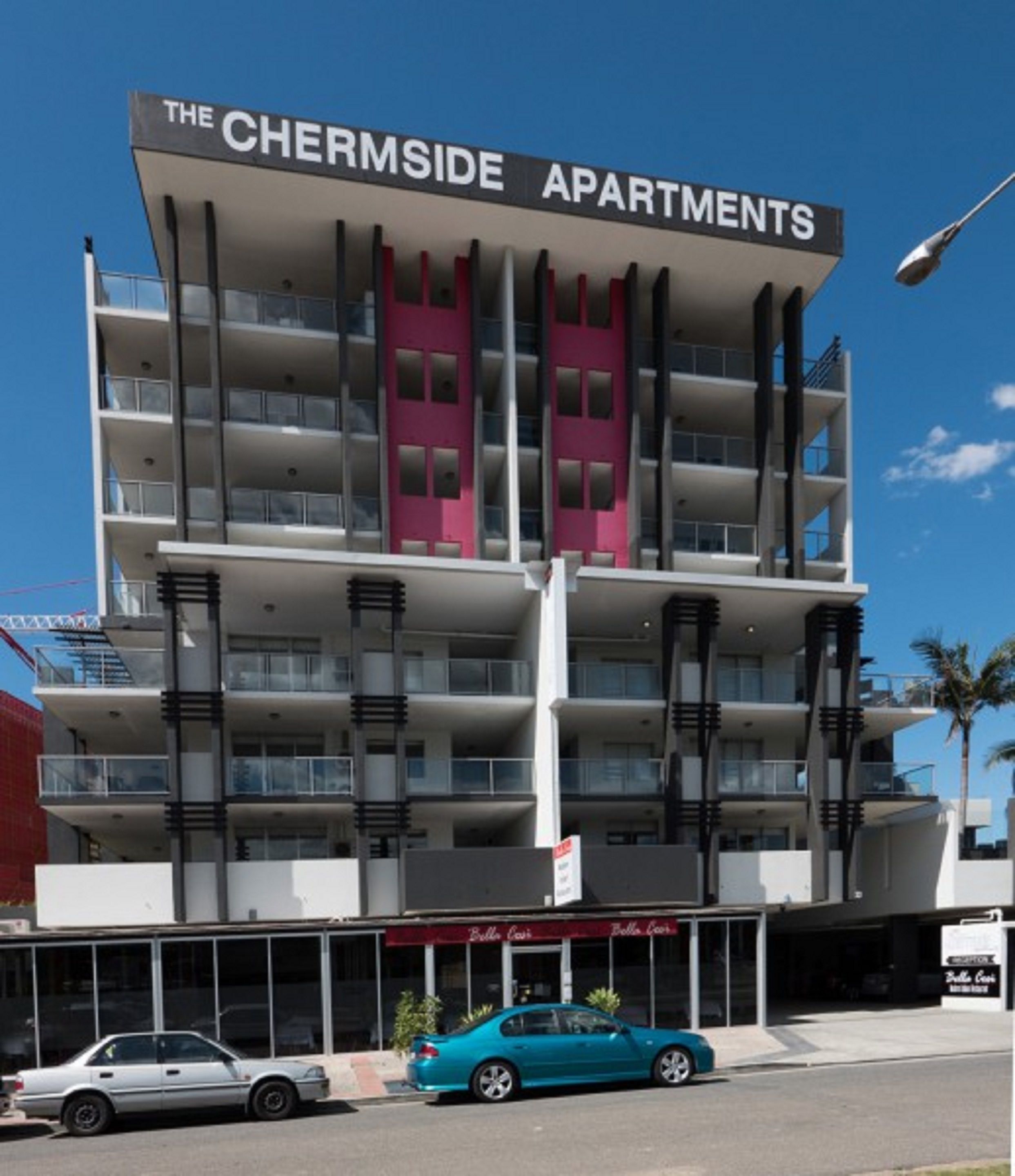 Un immeuble à plusieurs étages appelé « The Chermside Apartments », doté de balcons et d’une enseigne indiquant « Bella Casa ».