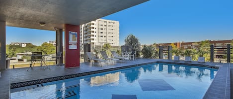 Una piscina al aire libre, tumbonas