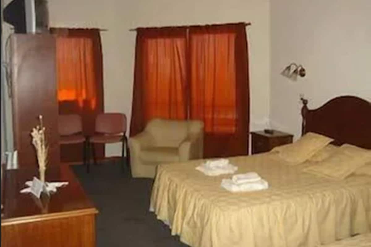 Une chambre d’hôtel comprenant un lit, un bureau, une chaise et une table de chevet.