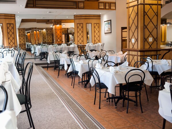 Un restaurante con varias mesas y sillas dispuestas en filas.