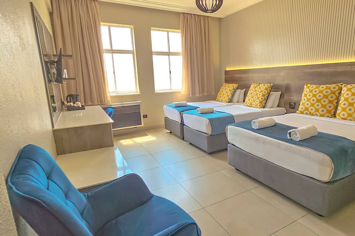 Een hotelkamer met twee bedden, een bureau en een stoel.