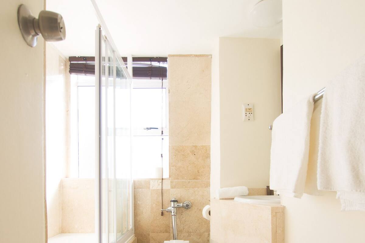 Een kleine badkamer met toilet, wastafel en douche.