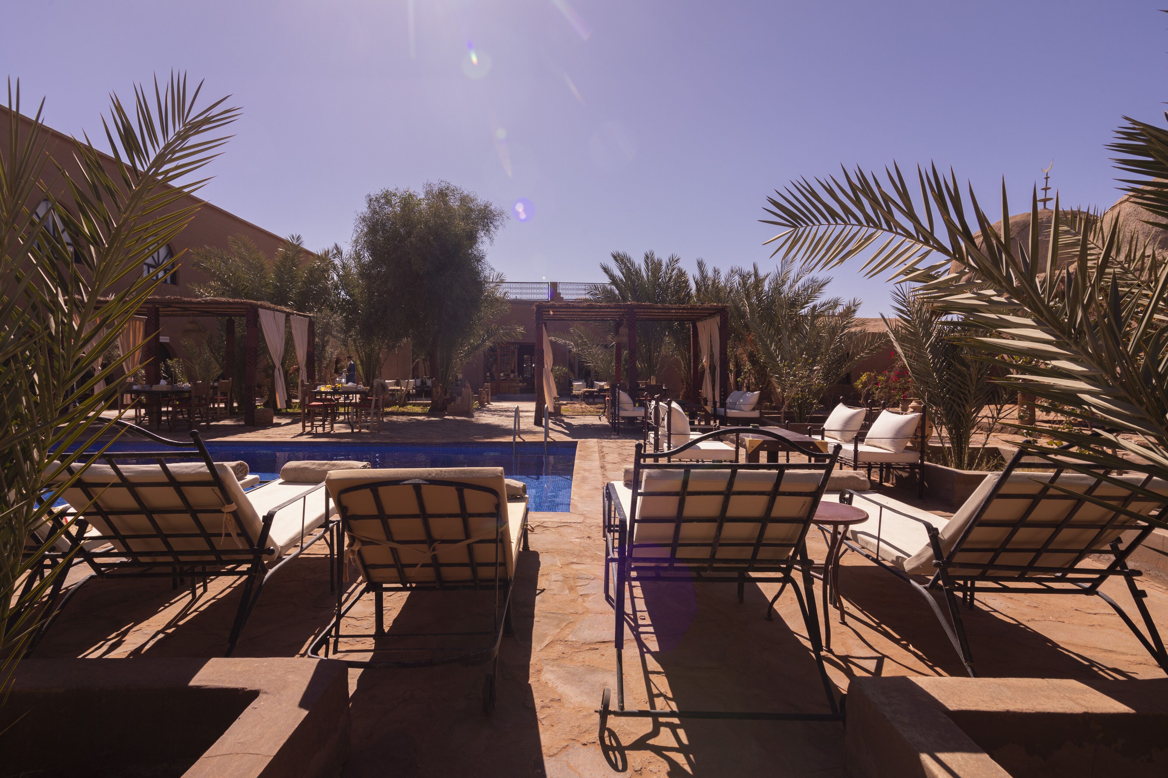 A poolside area with lounge chairs and a pergola.