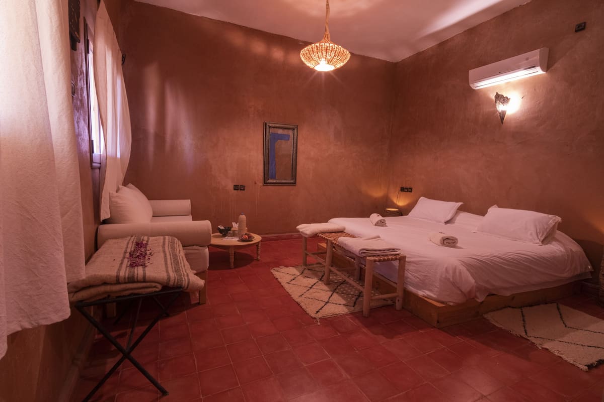 Une pièce confortable avec un lit, une petite table, une chaise et un canapé.