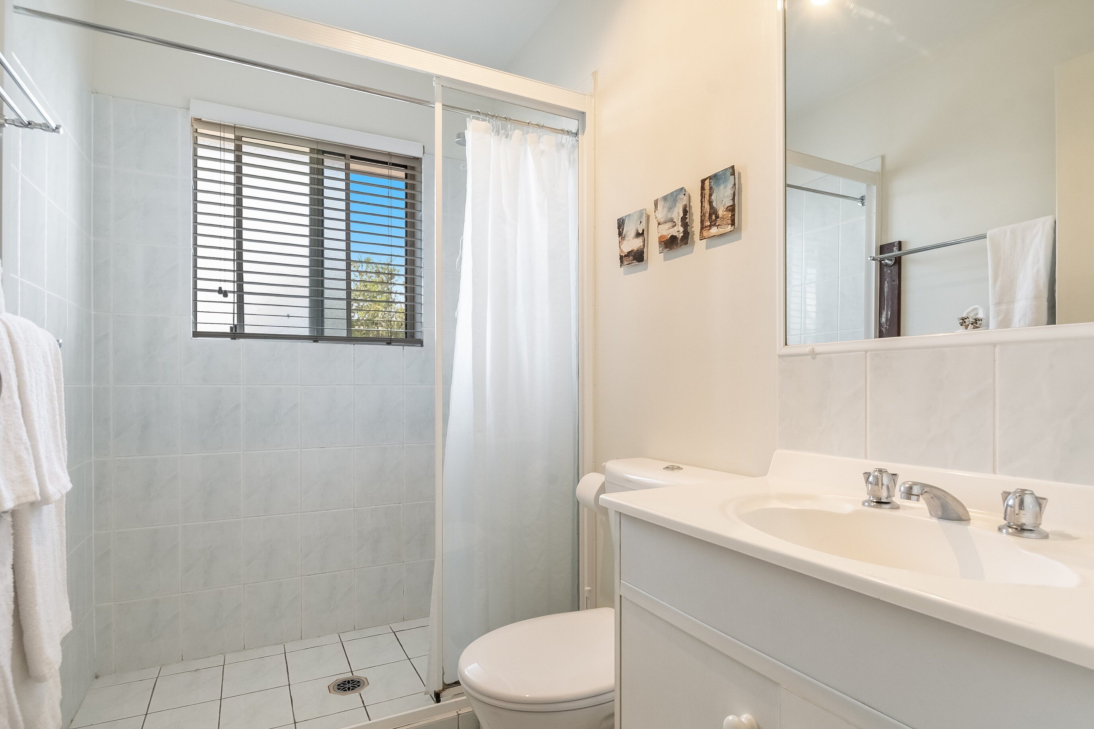 A bathroom with a shower, toilet, and sink.