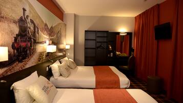 Une chambre d’hôtel avec deux lits, un tableau au mur, un bureau avec une chaise et un téléviseur fixé au mur.