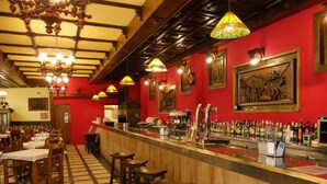 A restaurant with a bar area, wooden chairs, and a checkered floor. - Los Olmos (Lugo)
