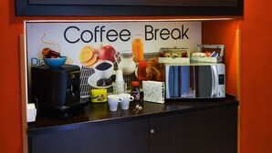 Estación para un descanso con cafetera, tazas y microondas.