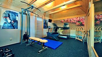 A gym with exercise equipment, a treadmill, and a blue mat.
