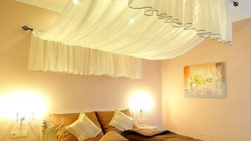 A bedroom with a bed, nightstands, and a canopy.