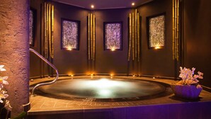 Un área de spa con hidromasaje, decoración de bambú y obras de arte enmarcadas en las paredes.
