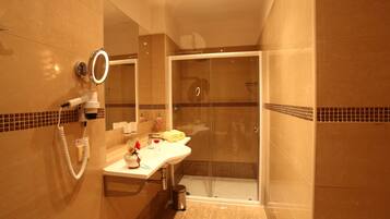 Een moderne badkamer met een douchecabine van glas, een wastafel met spiegel en een verwarmde handdoekrek.