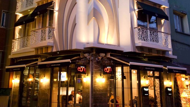 A multi-story hotel with a distinctive wavy facade and ornate balconies.