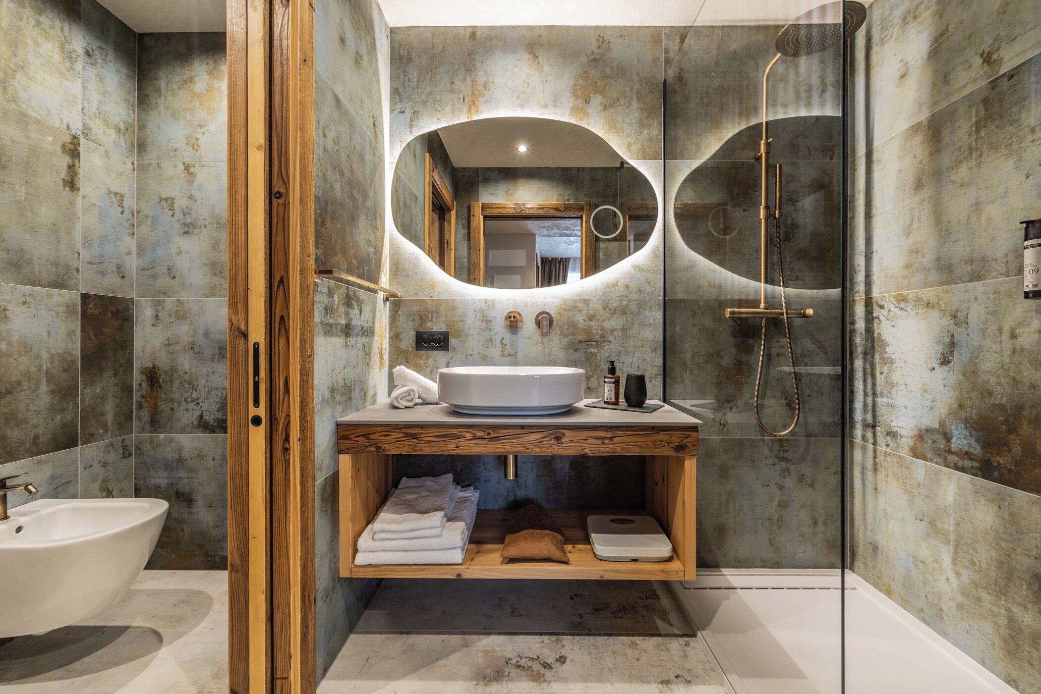 Ein modernes Badezimmer mit großem Spiegel, Waschbecken, Dusche und Holzschrank.
