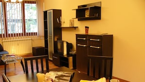 A dining area with a wooden table, chairs, a television, and a map. - BUZ Apart Sofia (Sofia)