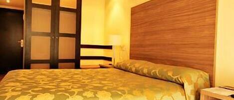 Un dormitorio con cama, cabecero de madera y mesita de noche.