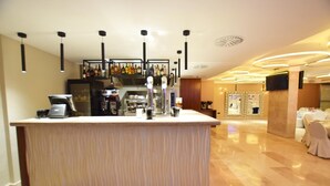 A bar area with a counter, bar stools, and a selection of bottles. - Hotel Centro Los Braseros (Burgos)