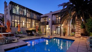 A modern two-story building with a swimming pool, outdoor seating, and a well-lit balcony area. - Derwent House (Cape Town)